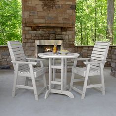 an outdoor table and chairs with fireplace in the background