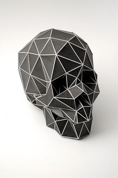 an origami skull made out of black and white paper on a white background