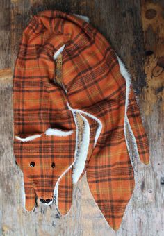 an orange and white plaid scarf with a dog's head sticking out of it