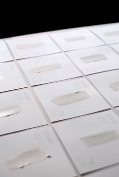 several rows of white business cards sitting on top of each other with holes in them