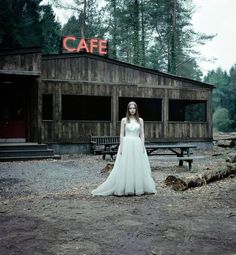 a woman standing in front of a wooden building