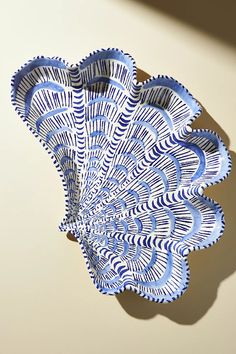 a blue and white decorative bowl sitting on top of a table next to a wall