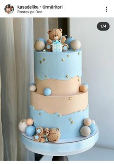 a three tiered blue cake with teddy bears on the top and stars around it