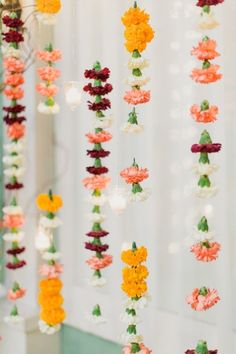 colorful flowers hanging from the ceiling in front of a mirror