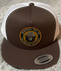 Yupoong 6006 flat-bill adjustable SnapBack  trucker hat with Smokey Bear  patch. Brown/white in color. Smokey Bear, Trucker Cap, Caps Hats, Trucker Hat, Accessories Hats, Accessory Gift, Forest, Electronic Accessories, Purses And Bags