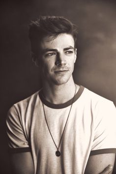 a black and white photo of a man in a t - shirt looking at the camera