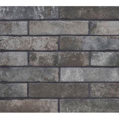 a brick wall made out of grey and brown bricks