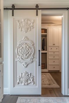 an open door leading to a closet with white furniture and drawers in the background is a carpeted area