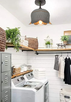 a washer and dryer sitting in a room next to some shelves with baskets