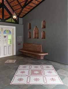 a room with a bench and rug on the floor