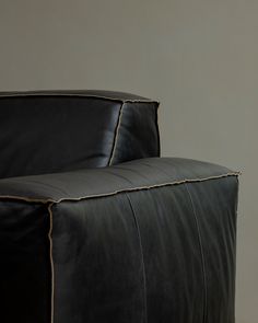 a black leather couch with gold piping