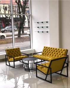 two yellow chairs sitting next to each other in front of a window