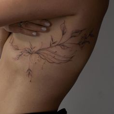 a woman's stomach with flowers and leaves on it