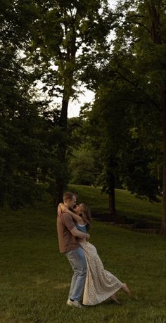 a man and woman are hugging in the grass