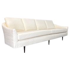 a white couch sitting on top of a wooden floor