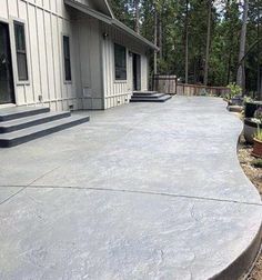 a concrete patio with steps leading up to the front door and side of a house