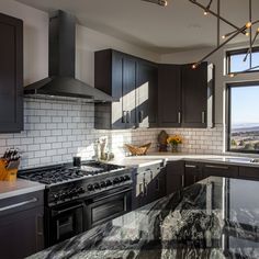 a kitchen with marble counter tops and stainless steel appliances, along with dark wood cabinets