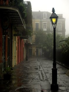 a street light on a rainy day with buildings in the background