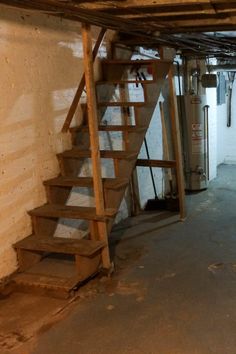 an unfinished basement with stairs leading up to the second floor and a fire hydrant