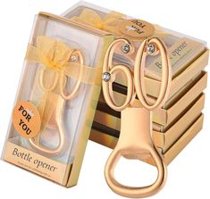 a pair of gold scissors sitting in a box next to it's packaging package