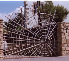 a large metal object sitting on the side of a road next to a brick wall