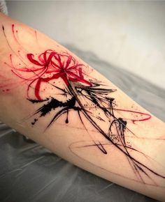 a woman's leg with red and black ink splattered on it