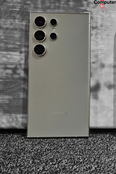 the back side of a silver cell phone with four buttons on it's sides