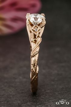 a close up view of a gold ring with an intricate design on it's side