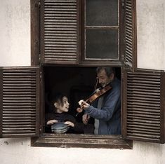 an old man playing the violin with a young boy