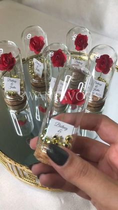 a person holding some bottles with flowers in them and labels on them that say love