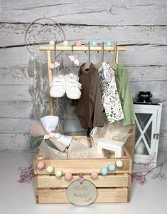 a wooden box filled with baby items on top of a white table next to a wall