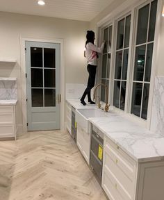 a woman standing on top of a kitchen counter