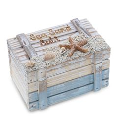 a wooden box filled with sand and starfish sitting on top of a white floor