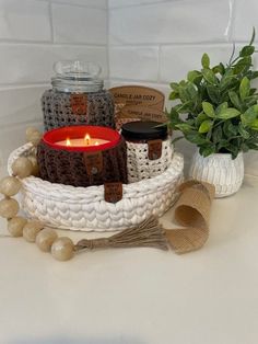 a candle is sitting in a basket next to some other items on a counter top