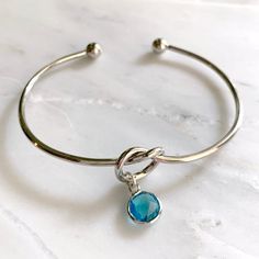 DETAILS:- Adjustable knot cuff bracelet- Bezel set crystal charm color: aquamarine- Silver or gold finish- Handmade in Miami- Nickel and lead freeSHOP THE COLLECTION:https://www.etsy.com/shop/TigerlillyCouturePACKAGING:Arrives in a custom Tigerlilly box, perfect for gifting and storing the jewelry.Printed receipts are not included in the box. You may print a receipt directly from Etsy for your records.If it is a gift, we will print your custom gift message and include it in the package.To includ Light Blue Bangle Jewelry Gift, Light Blue Bangle Jewelry For Gift, Light Blue Bangle Bracelets As A Gift, Bracelet Knot, Adjustable Knot, Bracelet Knots, Birthstone Bracelet, Knot Bracelet, March Birthstone