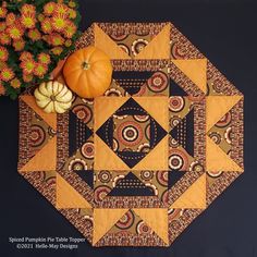 an orange pumpkin sitting on top of a table next to a vase with yellow flowers