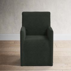 a green chair sitting on top of a hard wood floor next to a white wall