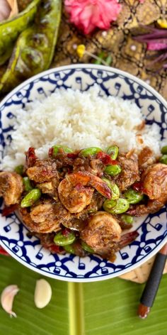 a blue and white plate topped with rice and shrimp