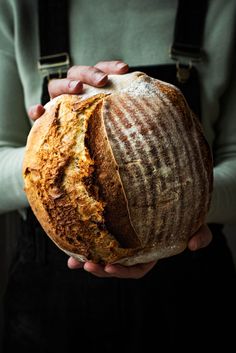 a person holding a loaf of bread in their hands