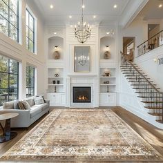 a large living room with white walls and wood flooring on the floors, along with a fireplace