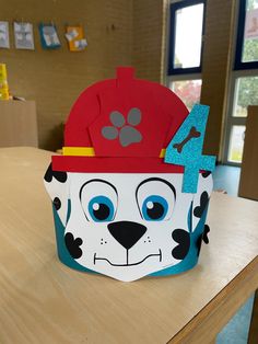 a paper cup with a fireman's hat on it sitting on top of a table