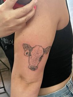 a woman with a cow tattoo on her arm