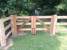 a wooden fence with gate in the grass