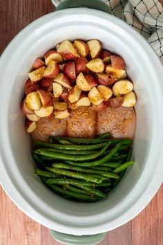 a white bowl filled with potatoes and green beans