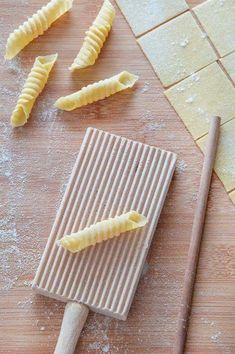 some food is laying out on a wooden table next to a spatula and rolling pin