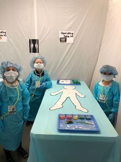 five doctors in scrubs stand next to a table with an x - ray image on it