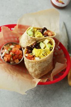 two burritos are sitting on a plate with salsa and avocado in it