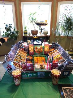 a table topped with lots of food on top of a green tablecloth covered floor