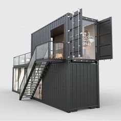 a black shipping container with stairs leading up to the second floor and windows on each side