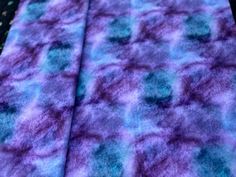 a purple and blue blanket laying on top of a table